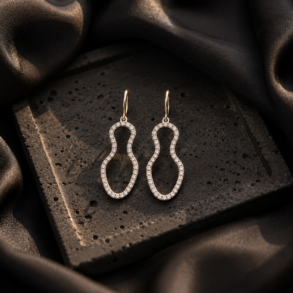Pair of silver earrings on a textured black surface 