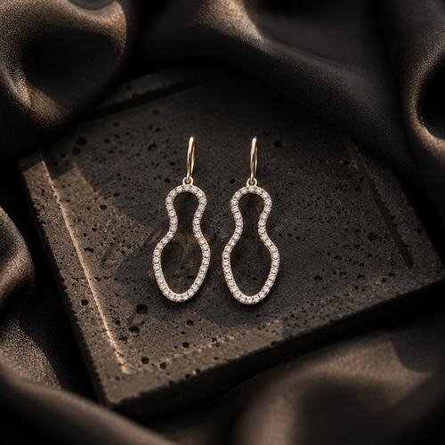 Pair of silver earrings on a textured black surface 