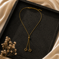 Double Clover Drop Pendant on a textured black stone tray.