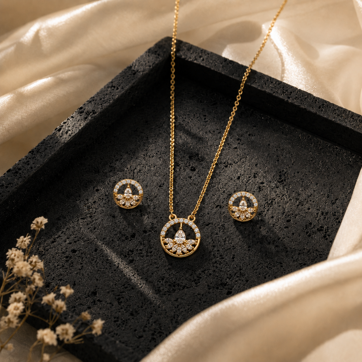 Floral Halo Pendant & Stud set on a black stone surface