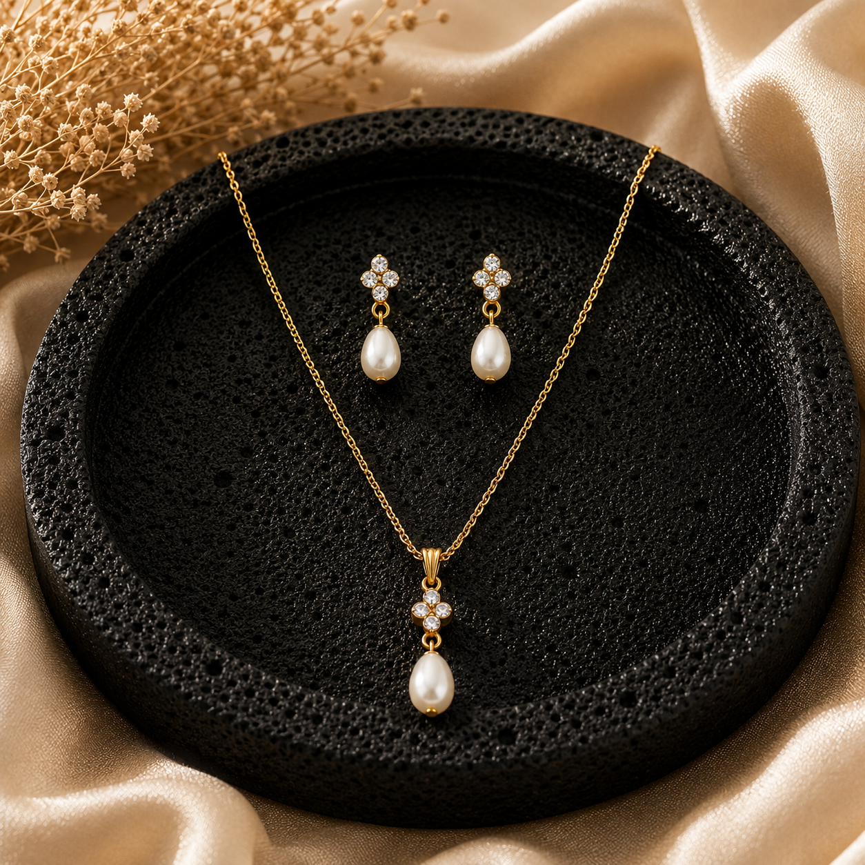 Pearl necklace and earrings set on a black textured surface