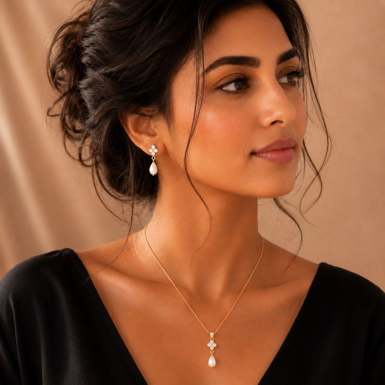 Woman wearing a necklace and earrings against a beige background