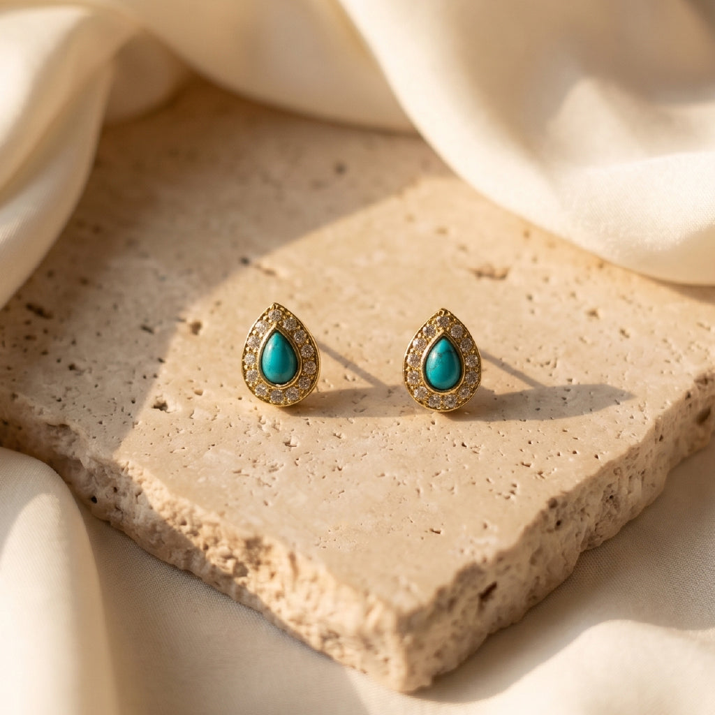 Turquoise-Blue Teardrop Studs on a textured stone surface.